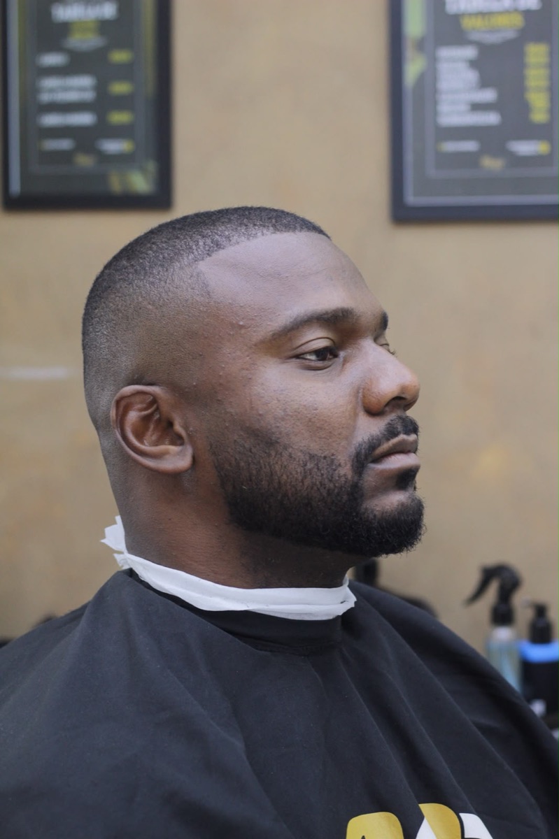 Cliente com corte curto, degradê lateral e barba alinhada